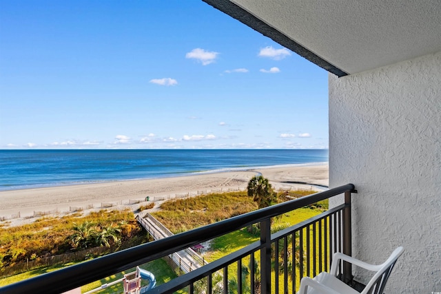 balcony featuring a beach view and a water view