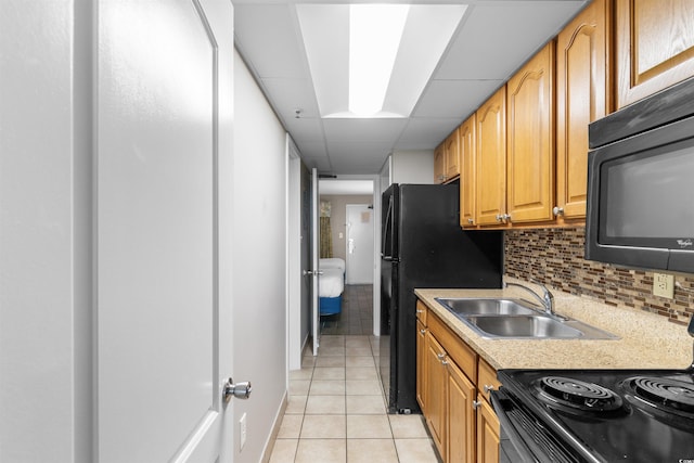 kitchen featuring tasteful backsplash, a drop ceiling, stainless steel range, sink, and light tile patterned floors