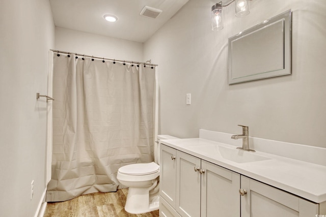 full bathroom featuring hardwood / wood-style flooring, vanity, toilet, and shower / tub combo