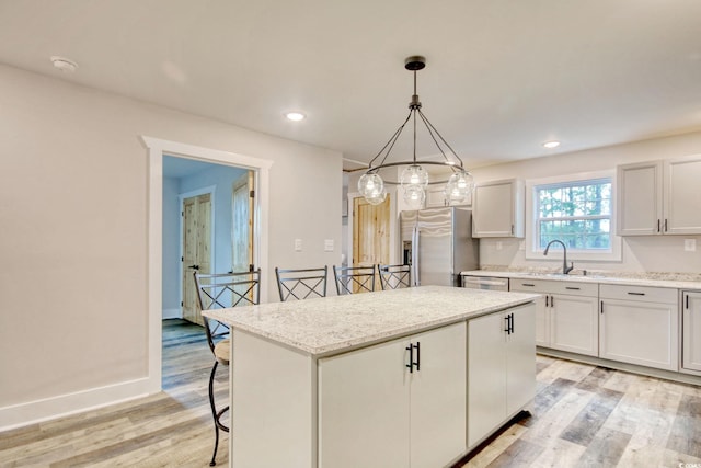 1409 Woodhaven Rd, Latta, SC 29565 - kitchen with stainless steel refrigerator with ice dispenser, a center island, light wood-type flooring, a kitchen breakfast bar, and pendant lighting