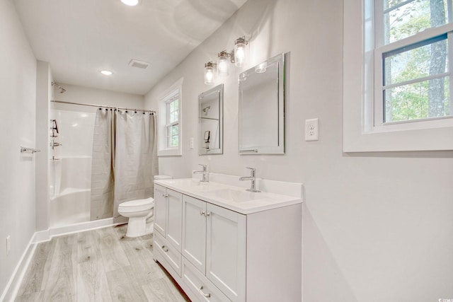 bathroom with a shower with curtain, vanity, hardwood / wood-style flooring, and toilet