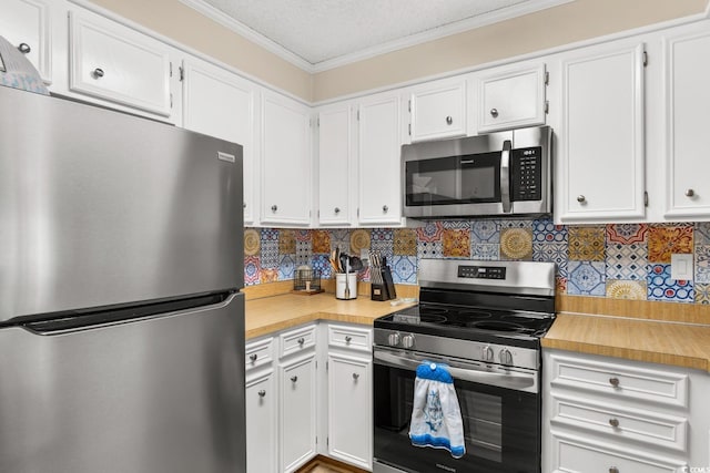 kitchen with white cabinets, stainless steel appliances, and ornamental molding