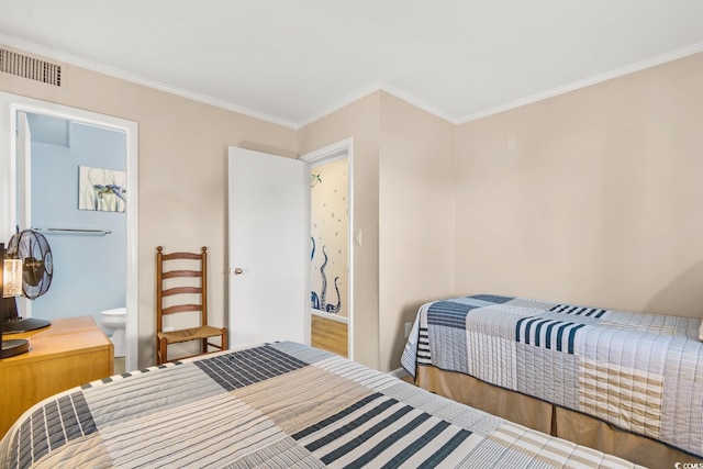 bedroom featuring hardwood / wood-style flooring, ensuite bath, and crown molding