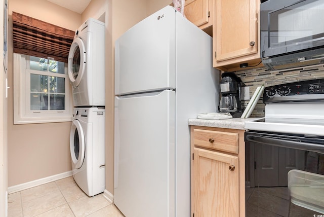 laundry area featuring stacked washing maching and dryer and light tile patterned floors