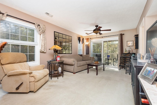 living room featuring light colored carpet and ceiling fan