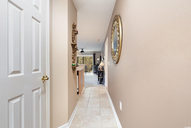 hall with a textured ceiling and light tile patterned flooring