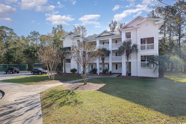 view of front of home with a balcony and a front lawn