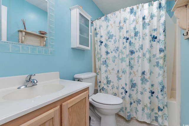 bathroom with a textured ceiling, vanity, and toilet