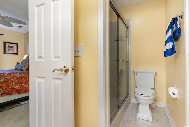 bathroom with tile patterned flooring, ceiling fan, toilet, and an enclosed shower