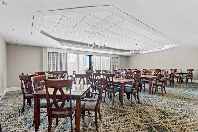 dining space featuring a notable chandelier, a tray ceiling, and carpet floors