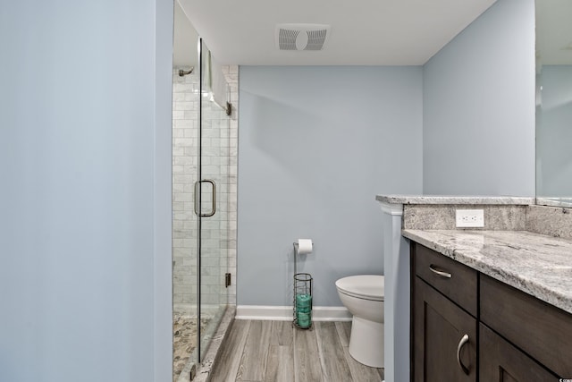 bathroom with vanity, an enclosed shower, hardwood / wood-style flooring, and toilet