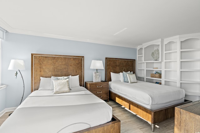 bedroom featuring ornamental molding and light wood-type flooring