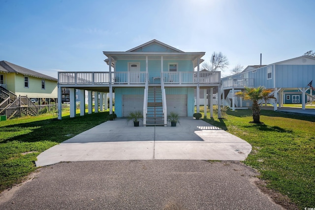 raised beach house featuring a front lawn, a porch, and a garage