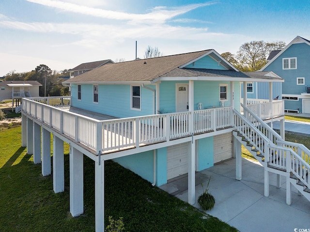 rear view of property featuring a garage and a porch