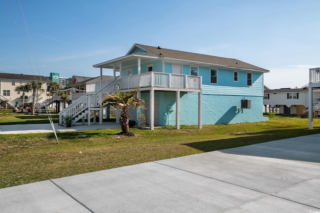 back of house featuring covered porch and a lawn