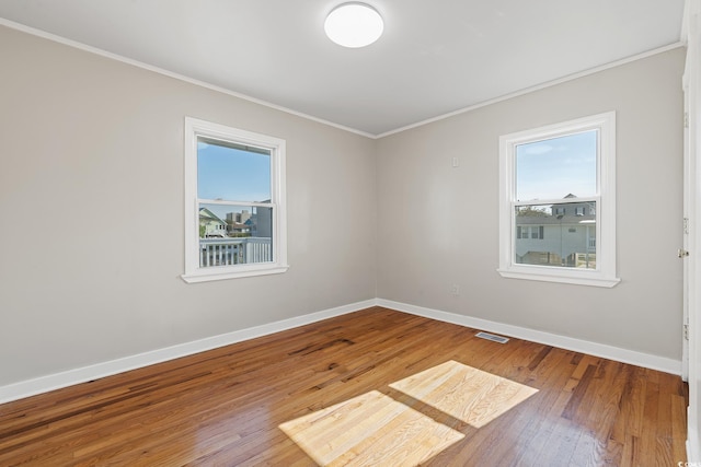 unfurnished room featuring ornamental molding and wood-type flooring