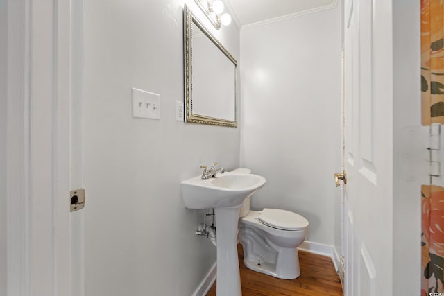 bathroom with toilet, wood-type flooring, and crown molding