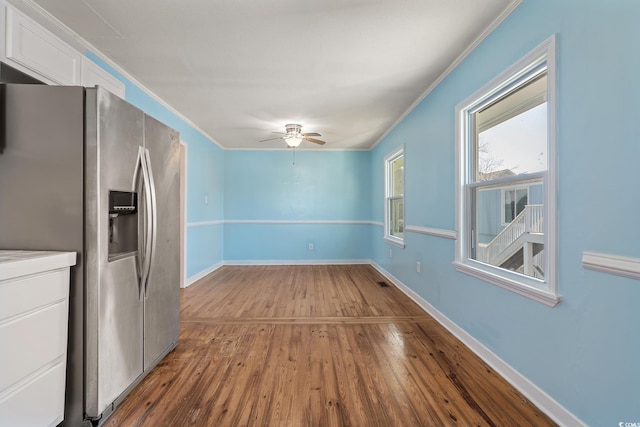 interior space featuring ceiling fan, ornamental molding, and wood-type flooring