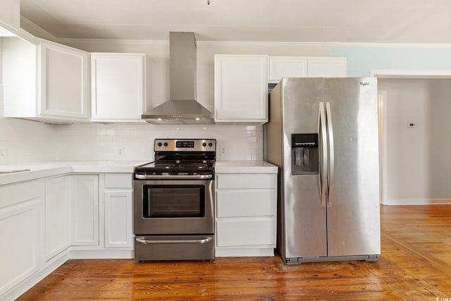 kitchen with dark wood-type flooring, white cabinets, wall chimney range hood, and appliances with stainless steel finishes