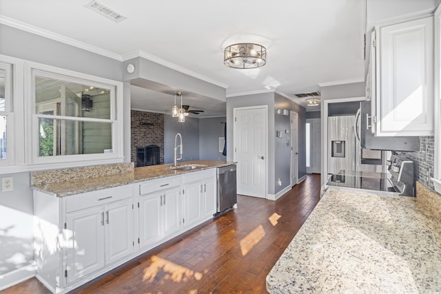 kitchen featuring white cabinets, sink, dark hardwood / wood-style floors, ornamental molding, and stainless steel appliances