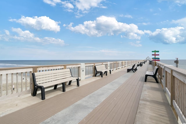 dock area with a water view and a beach view