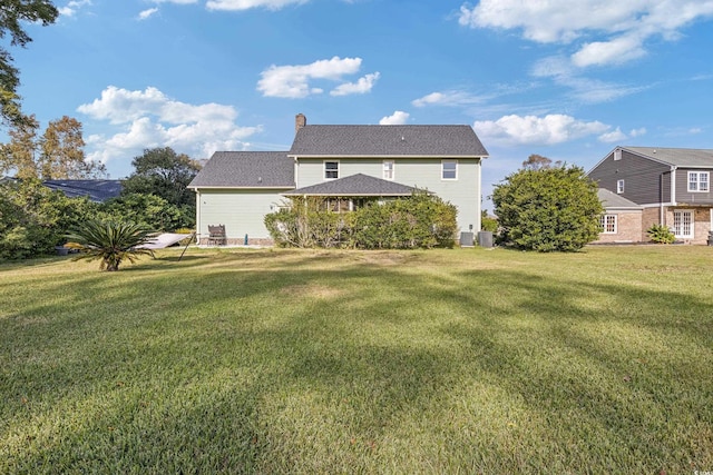 rear view of property with a lawn