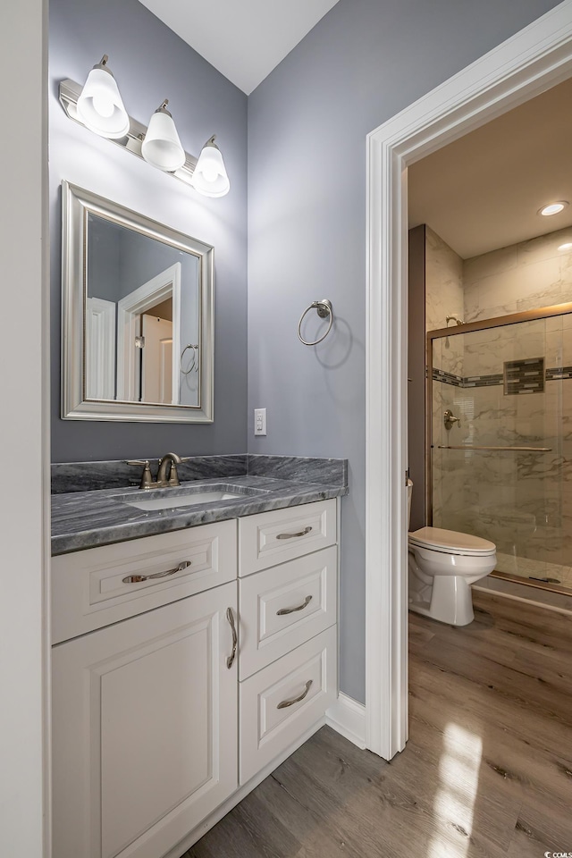 bathroom with vanity, hardwood / wood-style flooring, toilet, and walk in shower