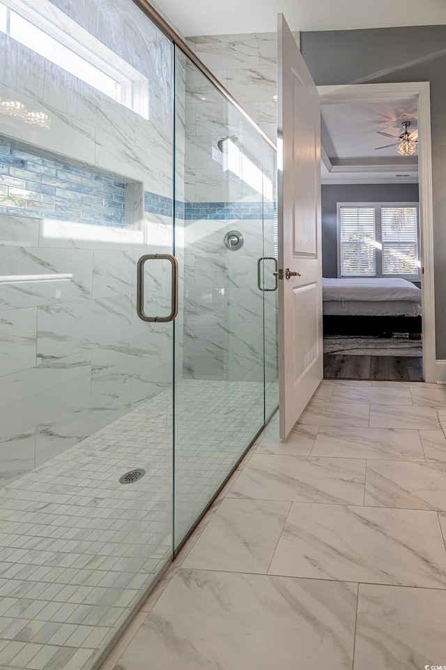 bathroom with ceiling fan, an enclosed shower, and ornamental molding