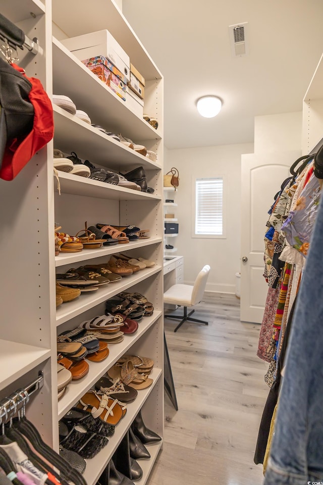 spacious closet with light hardwood / wood-style flooring