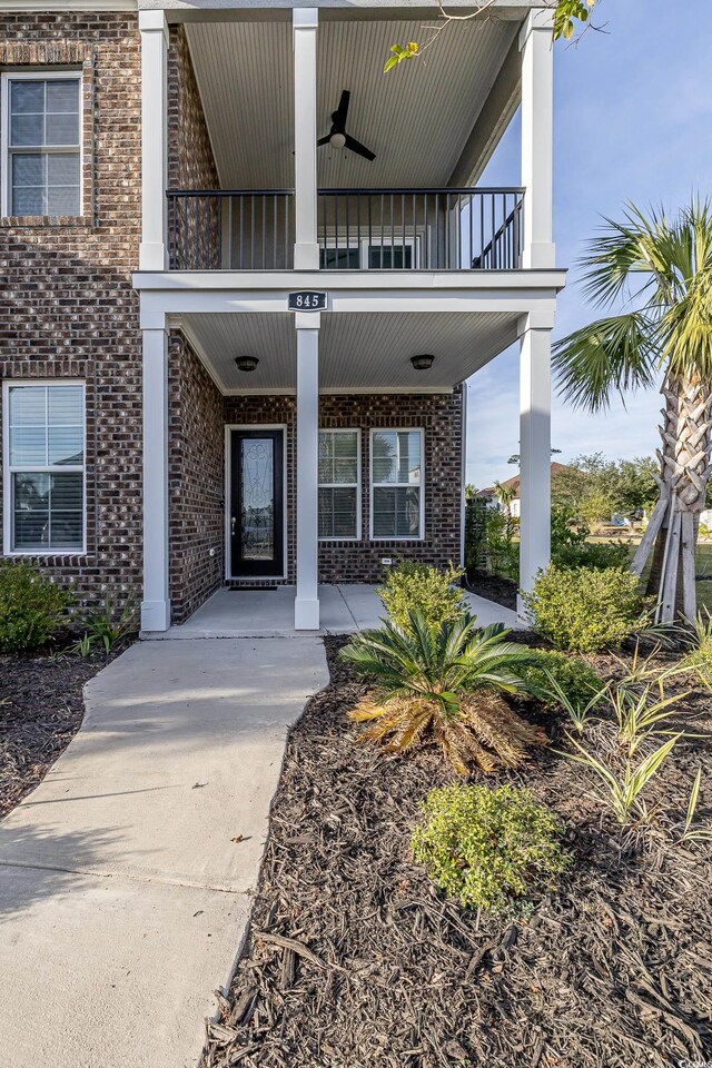 entrance to property featuring ceiling fan and a balcony