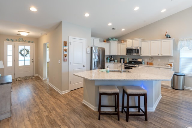 kitchen with hardwood / wood-style flooring, a wealth of natural light, white cabinetry, and appliances with stainless steel finishes