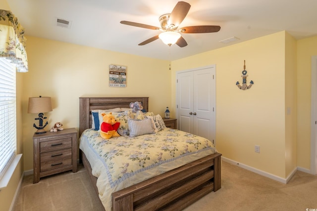 bedroom with ceiling fan, a closet, light carpet, and multiple windows