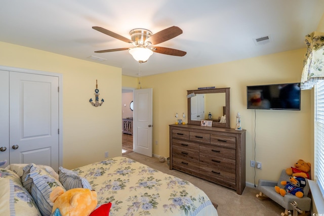 carpeted bedroom featuring ceiling fan and a closet