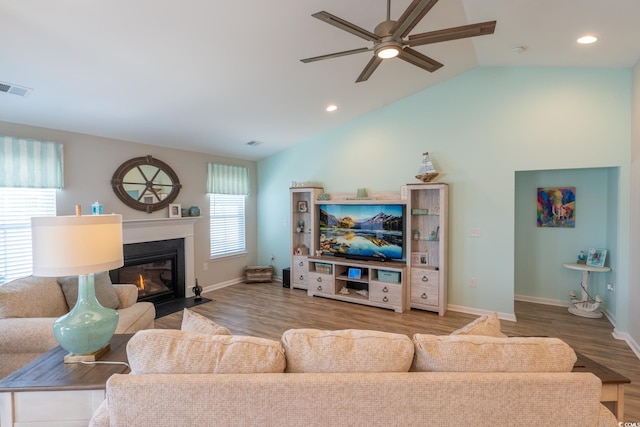 living room with ceiling fan, wood-type flooring, and vaulted ceiling