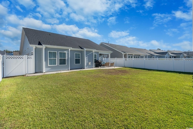 rear view of property with a yard and a patio