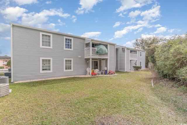 back of property featuring a lawn and a balcony