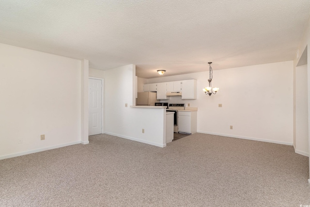 unfurnished living room featuring light colored carpet, a textured ceiling, and an inviting chandelier