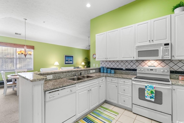 kitchen with kitchen peninsula, white appliances, white cabinets, and sink