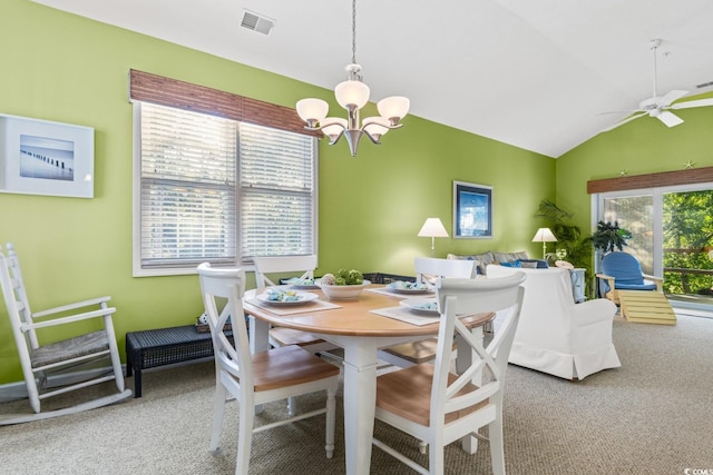 dining space featuring ceiling fan with notable chandelier, carpet floors, and lofted ceiling