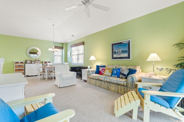 living room featuring lofted ceiling, carpet floors, and ceiling fan with notable chandelier