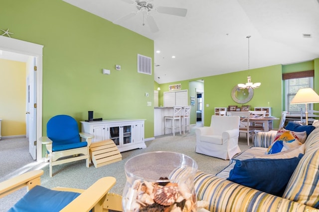 living room featuring vaulted ceiling, light carpet, and ceiling fan with notable chandelier