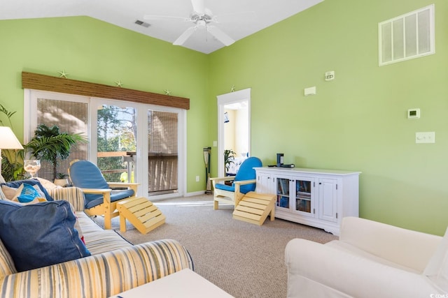 carpeted living room with ceiling fan and vaulted ceiling