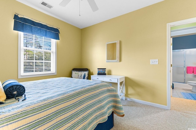 bedroom with ceiling fan, carpet floors, and ensuite bath