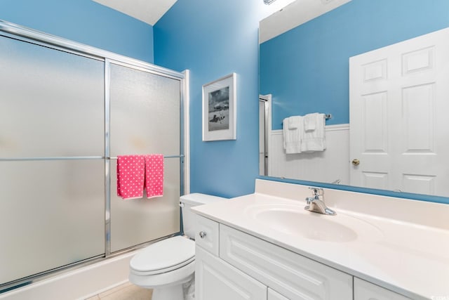 bathroom featuring an enclosed shower, vanity, toilet, and tile patterned flooring