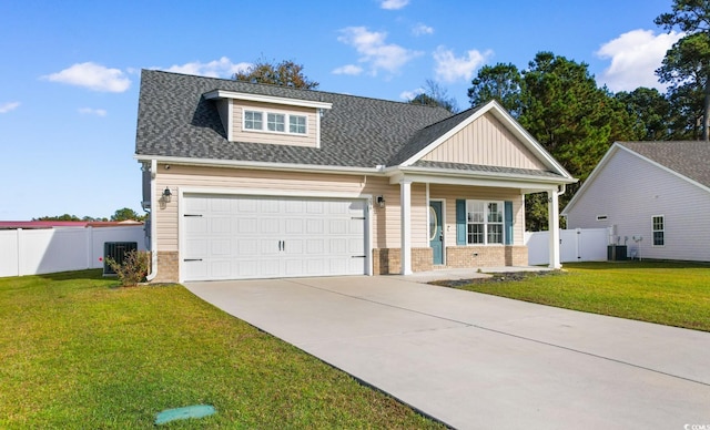 craftsman-style home with cooling unit, a front yard, and a garage