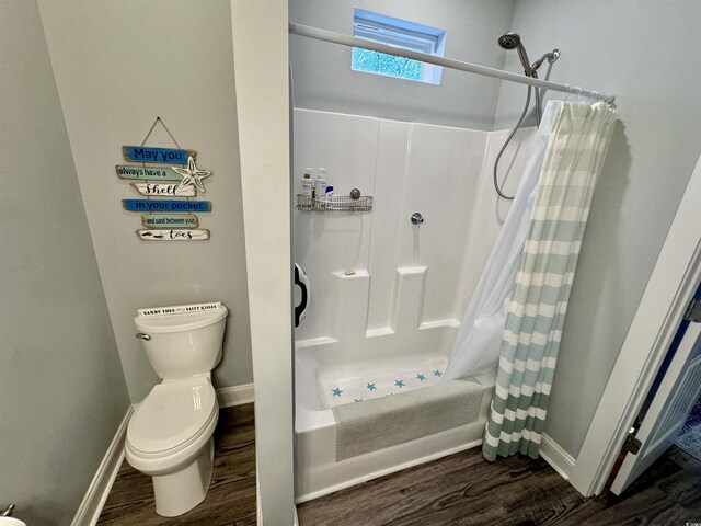 bathroom with shower / bath combination with curtain, wood-type flooring, and toilet