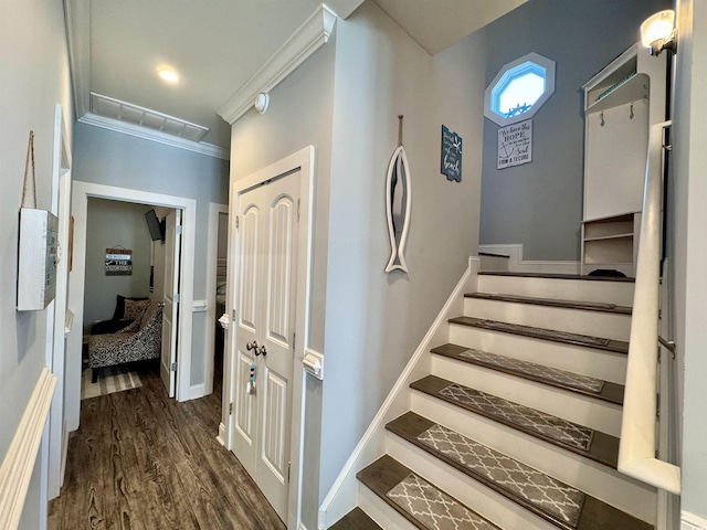 stairs with hardwood / wood-style floors and ornamental molding