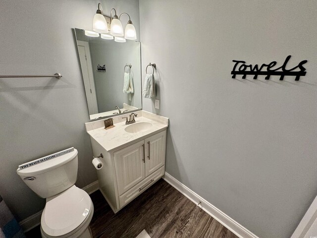 bathroom with hardwood / wood-style flooring, vanity, and toilet