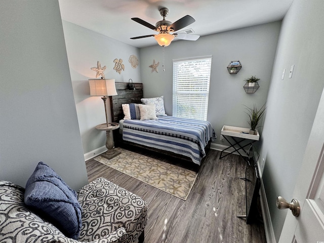 bedroom with dark hardwood / wood-style flooring and ceiling fan