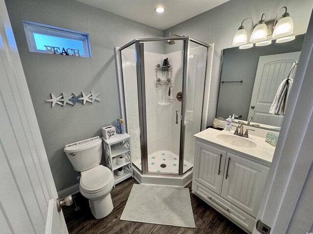 bathroom featuring hardwood / wood-style floors, vanity, toilet, and an enclosed shower